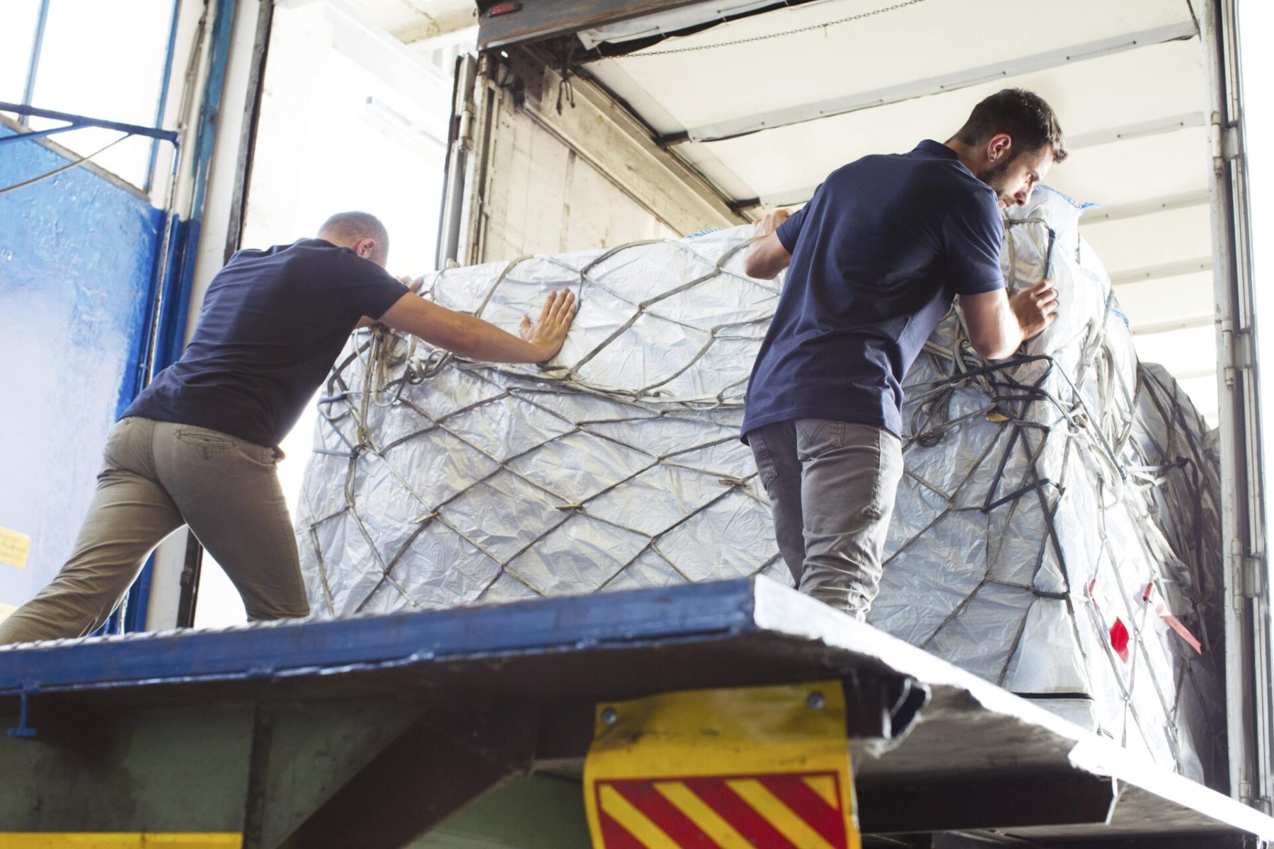 workers-pushing-freight-into-air-freight-container-2025-04-04-18-10-26-utc-min